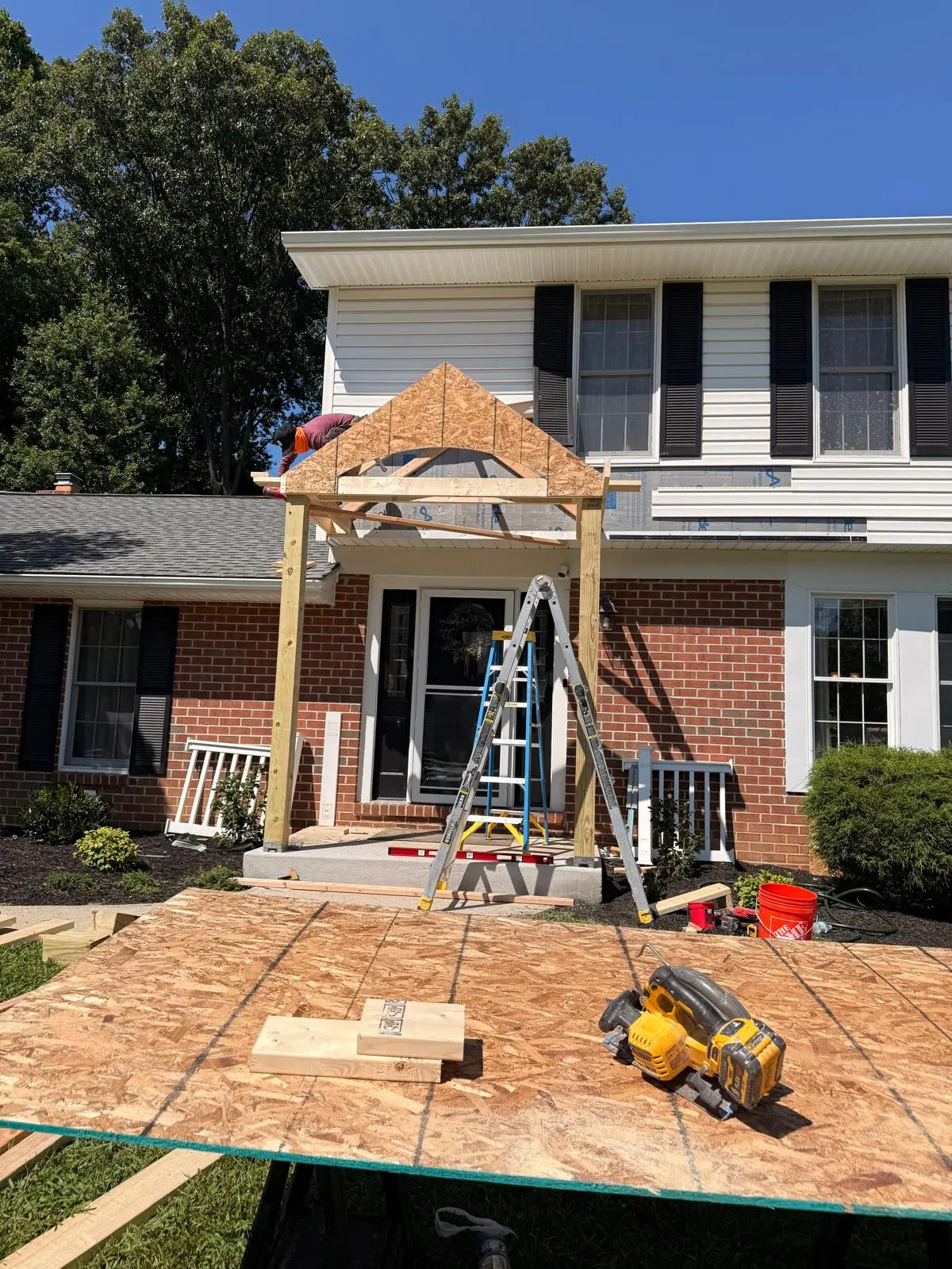 Front portico under construction with framed gable and new columns